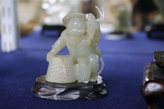 Two Chinese celadon jade figures of a fisherman and a lion-dog, 6.2 and 11cm, wood stands